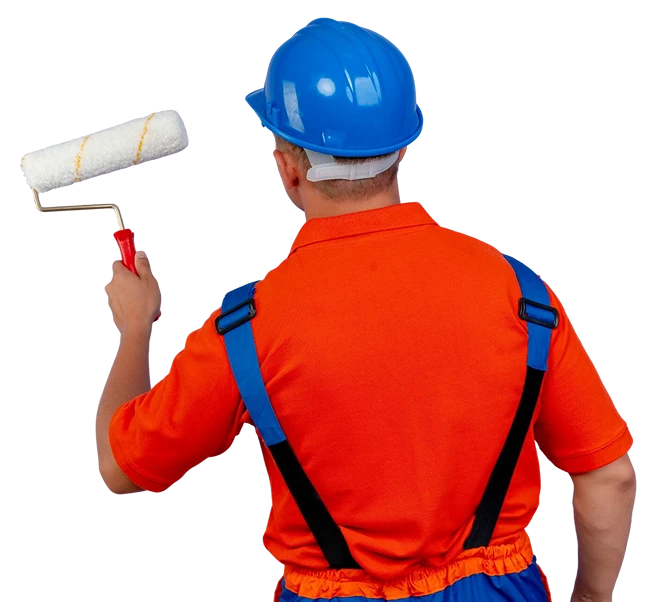 De pe atras da vista jovem construtor do sexo masculino usando uniforme e capacete de seguranca segurando o rolo de pintura em roxo